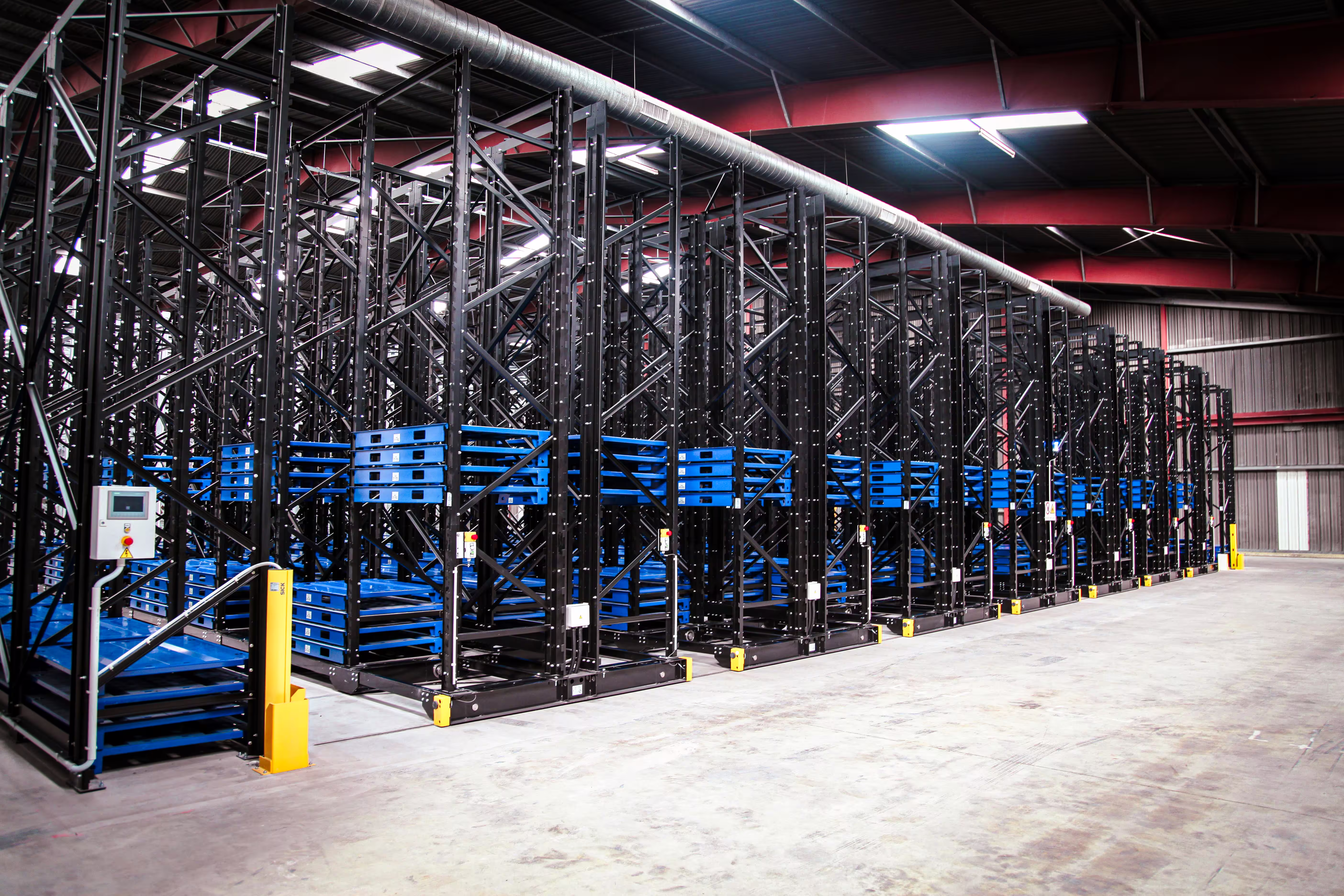 IARS mobile racking with its bays rolled closed against each other on the floor rails, the aisles between them eliminated so the stock occupies a continuous block