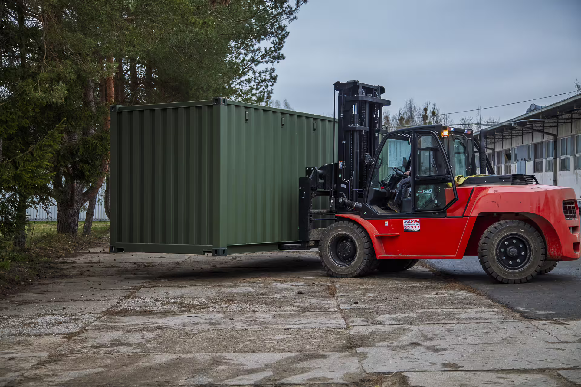 Green FlexiPod container lifted by a forklift, showing its mobility and easy deployment.