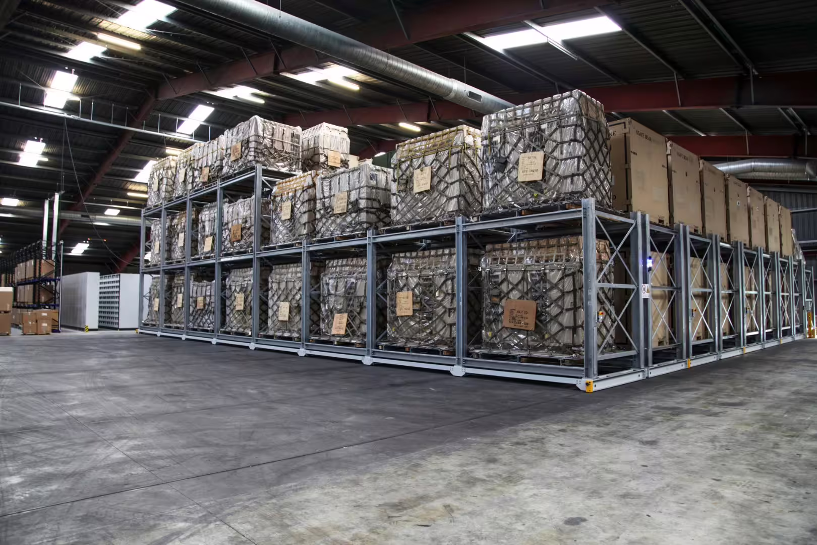 Three-tier IARS racking block densely loaded with cargo-netted 463L air pallets in a warehouse hall