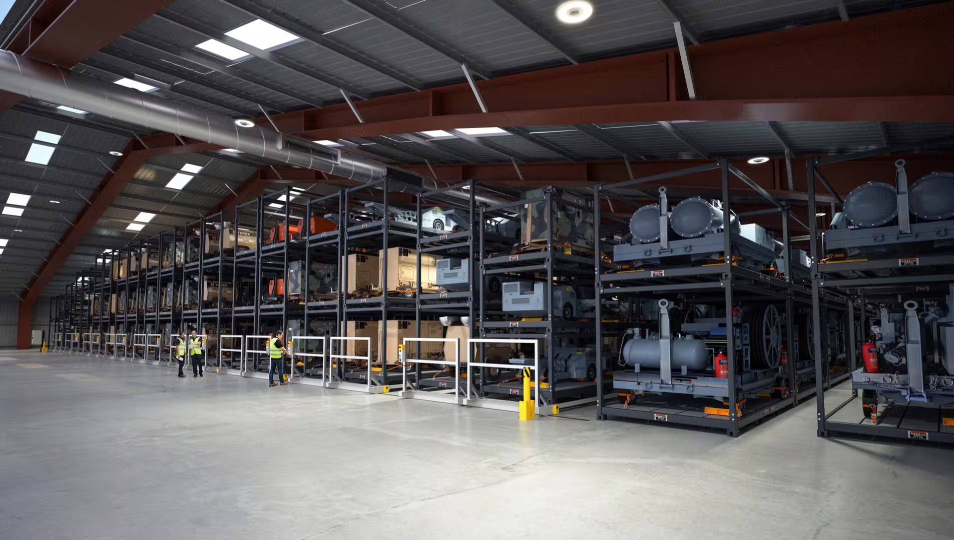 Military support equipment and generators strapped on three-tier heavy racking rows in a depot, workers in hi-vis at the aisle railings