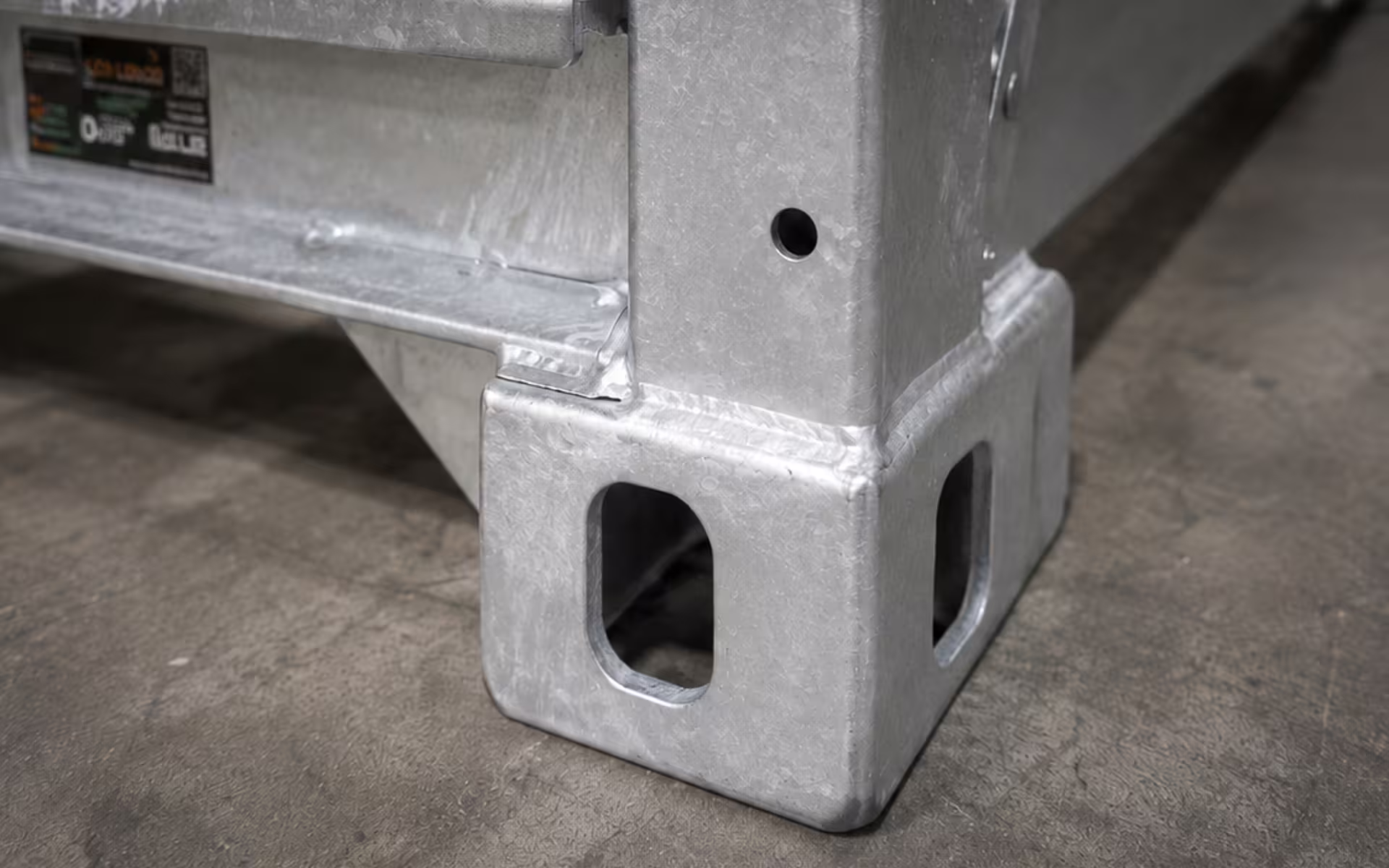 A close view of a CargoCuber corner casting, showing the twin location holes and the welded junction between the upright and the base rail