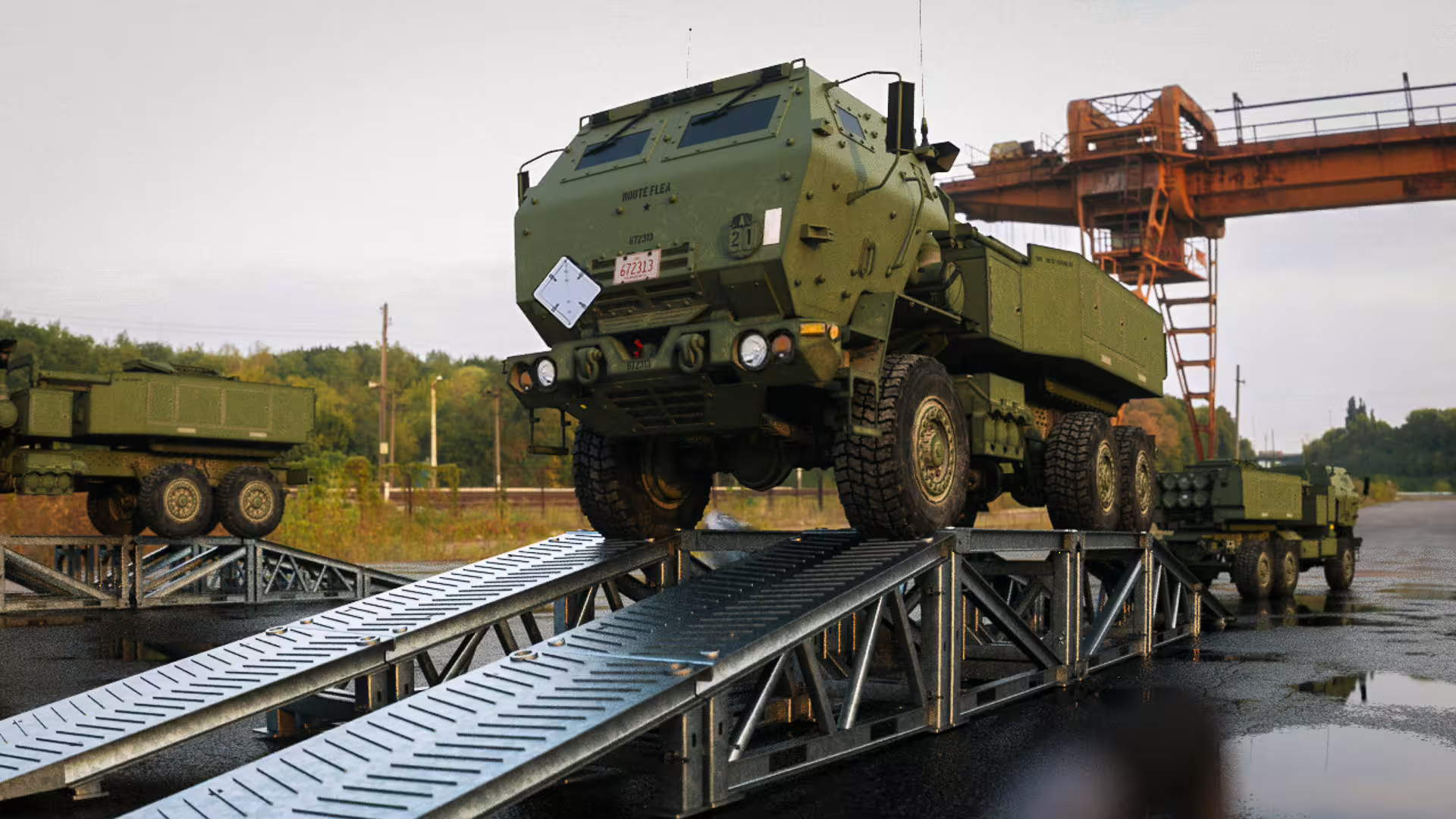 HIMARS launcher crossing a drive-through MUDR-PD50 ramp on wet hardstanding