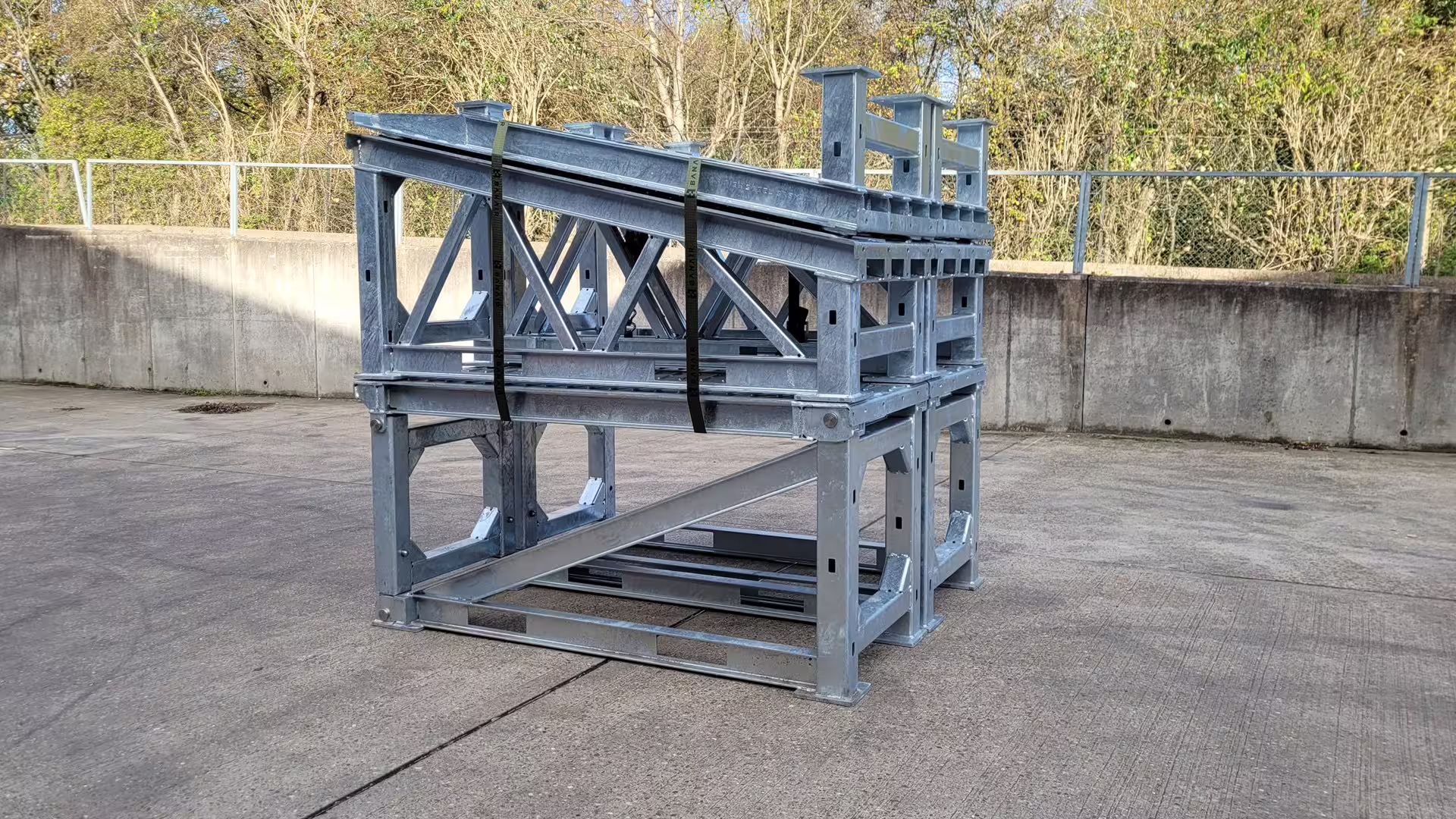 Galvanised MUDR platform sections stacked and strapped into a single transport package, banded onto timber bearers ready to ship
