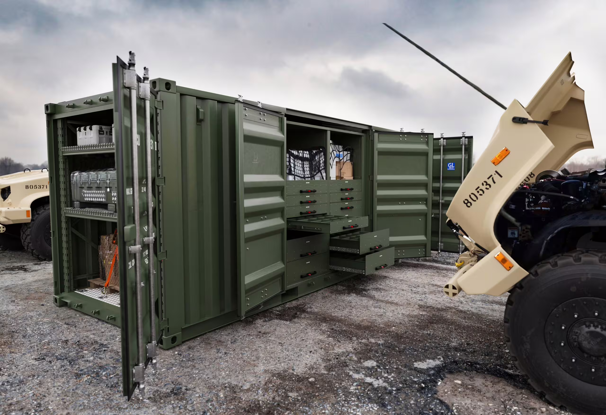 The long side of a green 20 ft Rackbox container with its side and middle cargo doors swung open, giving access to shelved transit cases, drawer stacks and a netted pallet bay in one span