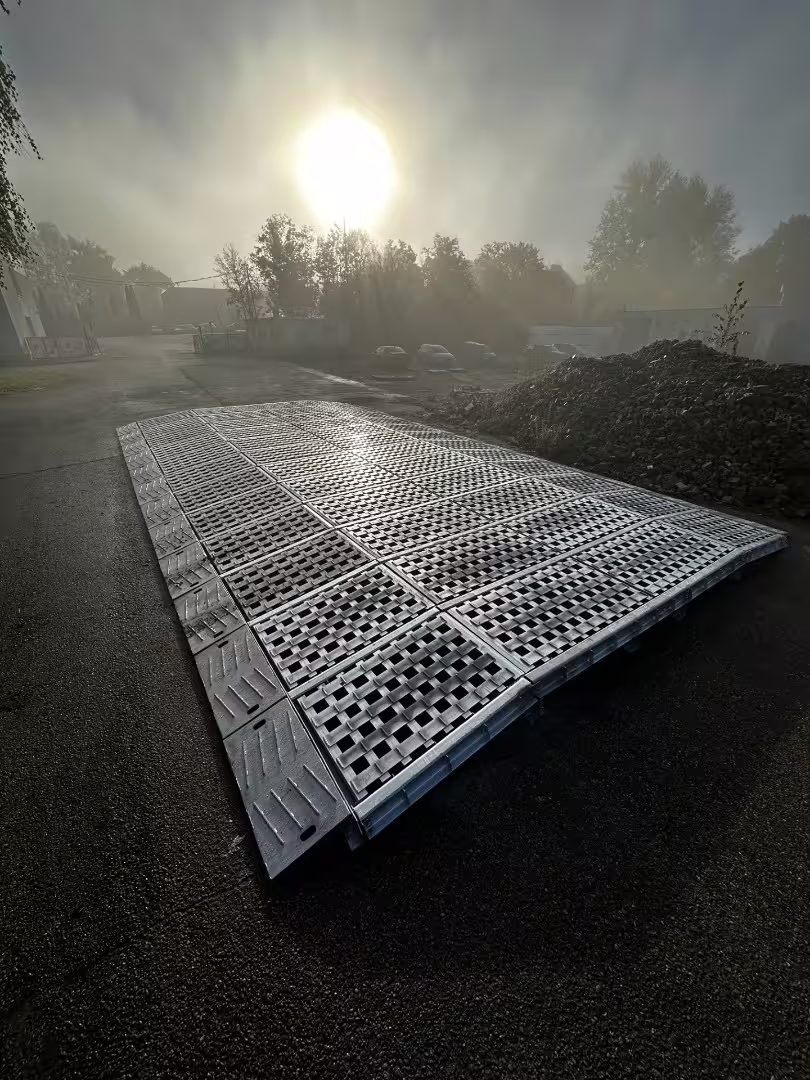 Assembled RM90 rail mat — galvanised anti-slip deck panels laid low on hardstanding