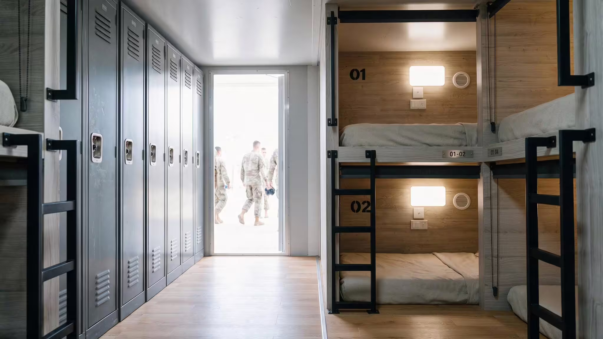 The interior of a BunkBox module looking down its length: a run of ventilated steel lockers along one side, enclosed bunk pods numbered 01 and 02 along the other, and an open door at the far end