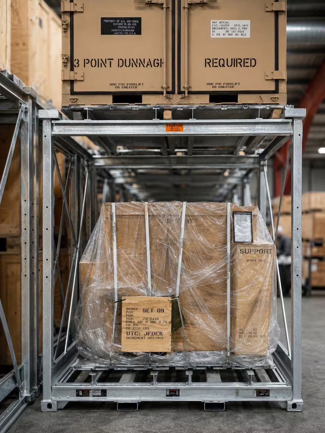 A single CargoCuber frame holding a shrink-wrapped pallet with a timber crate seated above it, the crate stencilled with a dunnage requirement